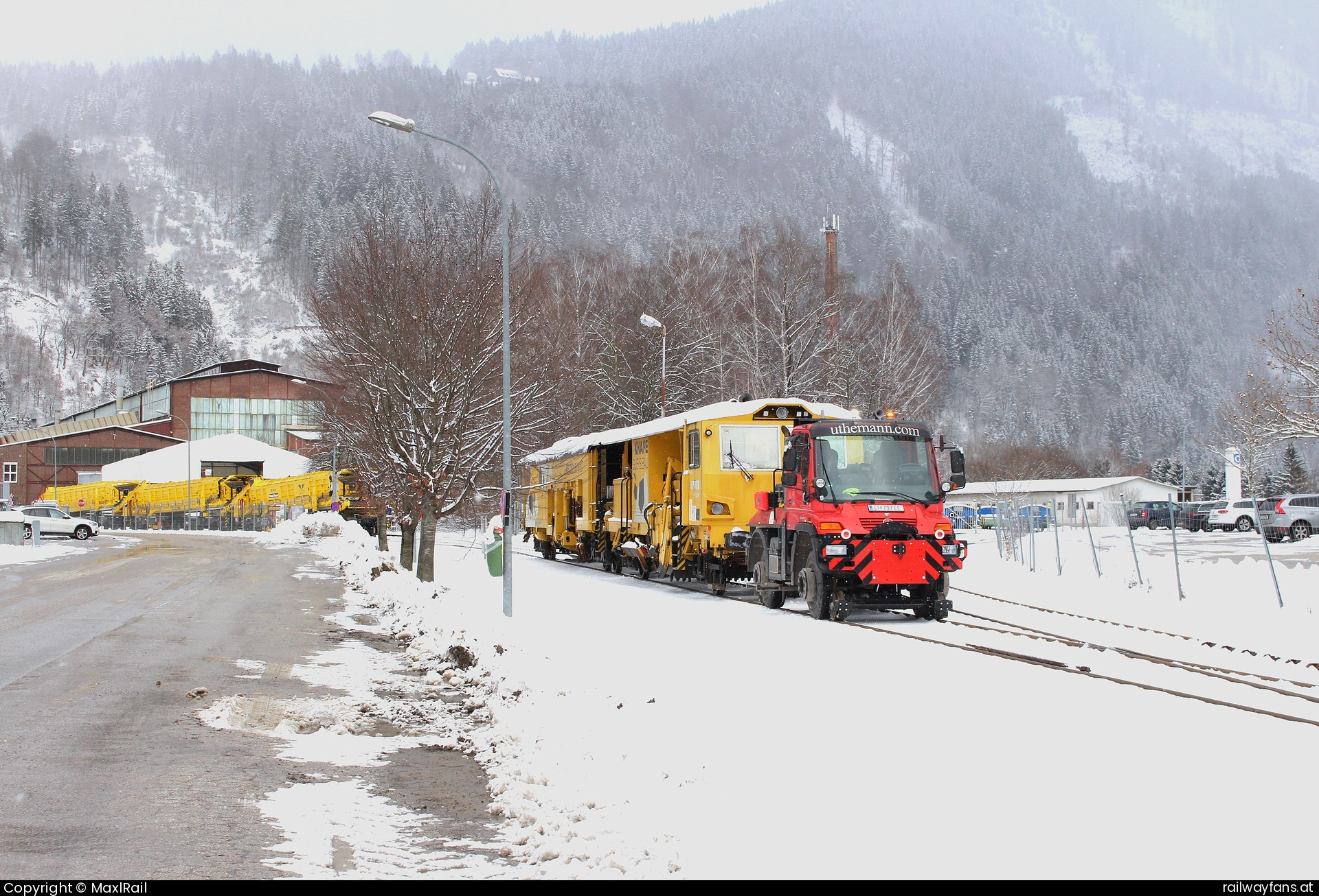 MFL Liezen U400 in Liezen - Die Maschinen Fabrik Liezen und Gießerei besteht seit 1939 auf ihrem Standort und besitzt eine Anschlussbahn zum Bahnhof Liezen.
Mit einem Zweiwege Unimog des Typs U400 werden unregelmäßig Güterwagen in oder aus der Anschlussbahn verschoben, die hier gebaut oder modernisiert werden.
Am 23.12.2024 verschiebt der funkgerngesteuerte U400 einer Plasser&Theurer Stopfmaschine.   Railwayfans