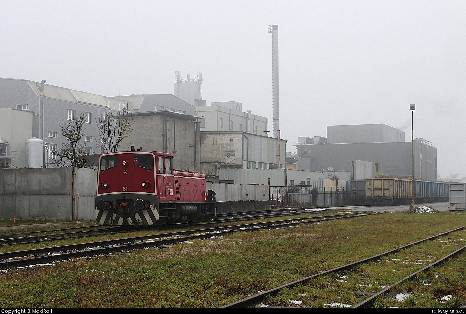 Agrana V81 in Enns - Auf dem Gelände der 1989 geschlossenen Zuckerfabrik in Enns haben sich neben einigen Firmen auch ein Kulturzentrum angesiedelt. Der Rübenplatz blieb zum verladen von Güterwagen bestehen und wird jedes Jahr für die Rübenkampagne genutzt.
Die ehemalige SLB V81 verschiebt vor der Kulisse der alten Fabrik am 6.1.2025 einige Güterwagen auf der Anschlussbahn.   Railwayfans