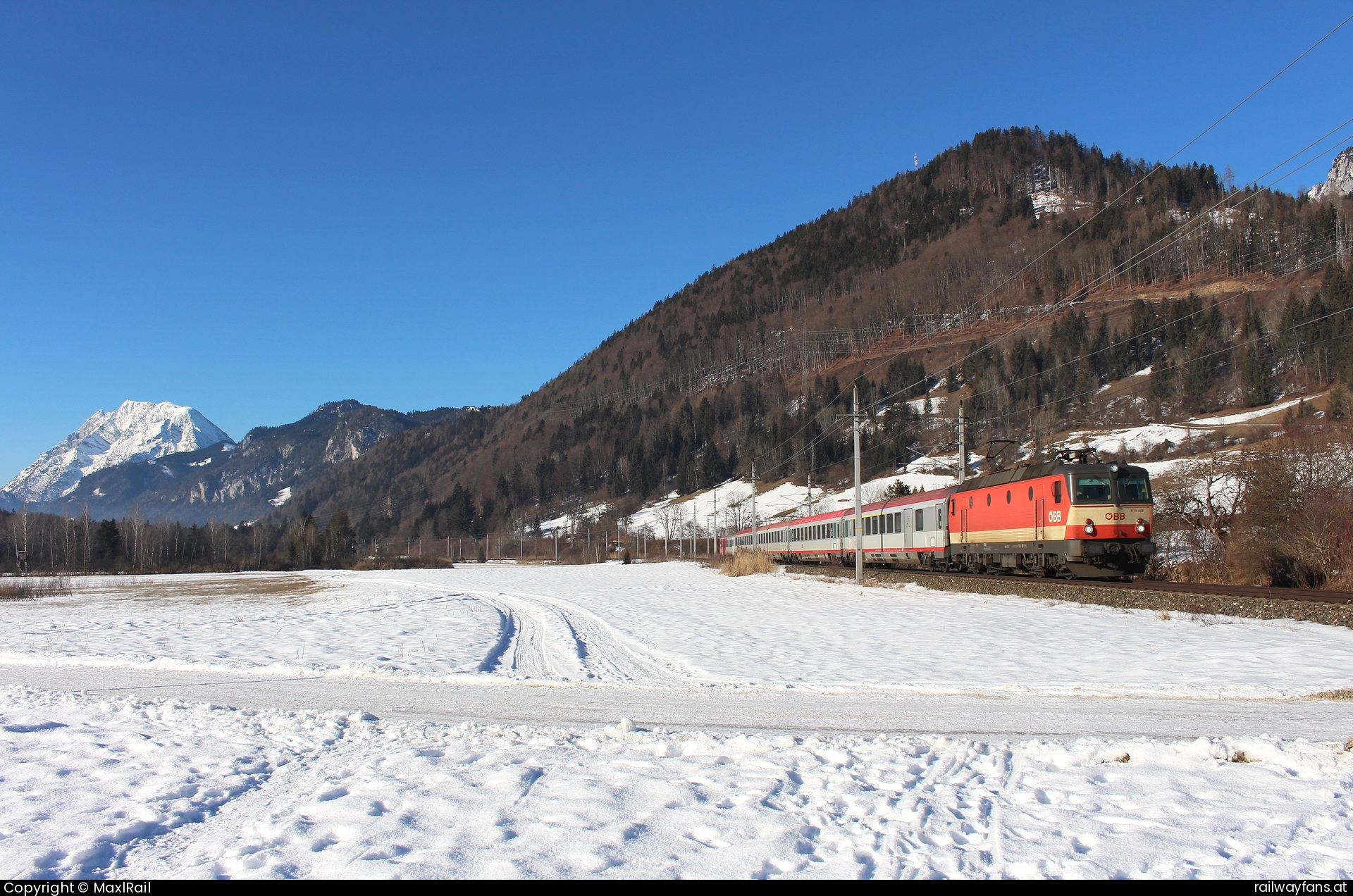 ÖBB 1144 092 in Wörschach mit dem IC 513 - Vor dem Panorama des 2351m hohen Grimming fährt am 19.1.2025 die 1144 092 mit dem IC513 