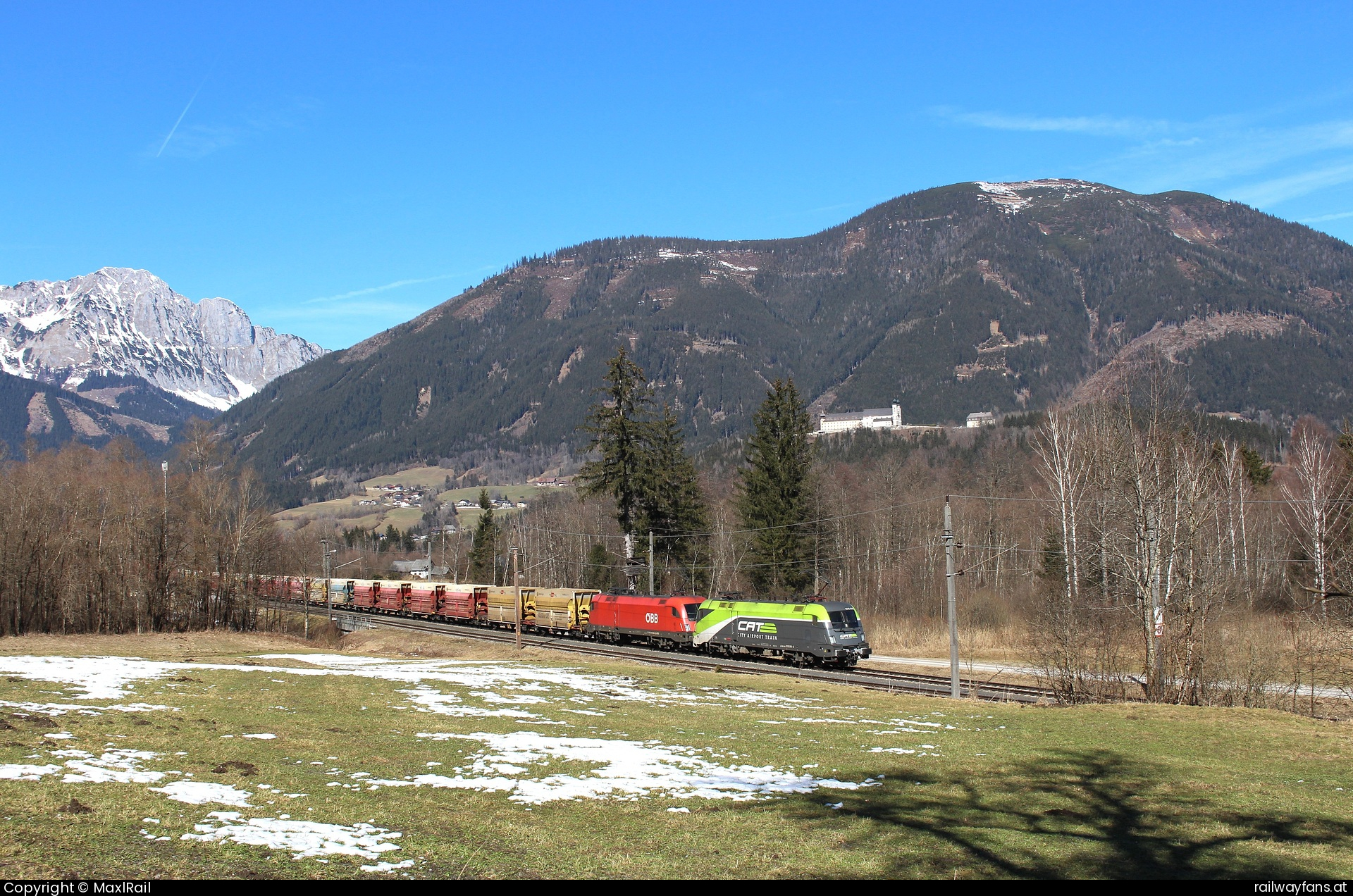 ÖBB 1016 016 in Frauenberg an der Enns - Die Walfahrtskirche Frauenberg/Enns aus dem 15. Jahrhundert wird, trotz ihrer Lage 130m über dem Talboden, vom 1720m hohen Pleschberg überragt.
Im Tal windet sich die Gesäusestrecke entlang der Enns und wird hier am 3.3.2015 von der 1016 016 und der 1016 024 mit einem leeren Erzzug von Selzthal nach Eisenerz befahren der den Bahnhof Frauenberg an der Enns durchfährt.  Gesäusebahn Railwayfans