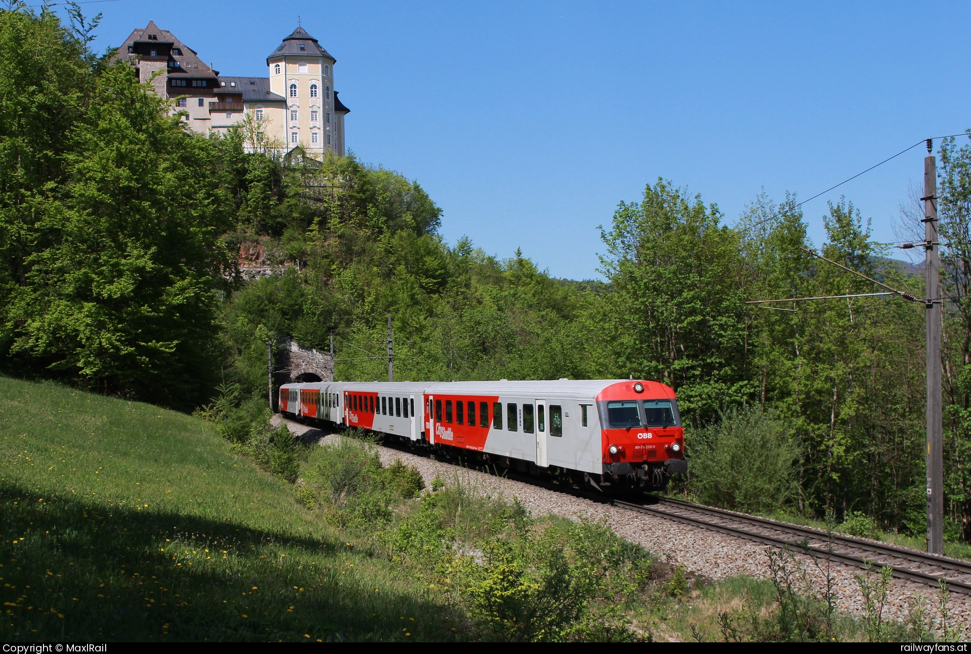 ÖBB 1144 242 in Klaus an der Pyhrnbahn mit dem REX 3907 - Kurz hinter dem Bahnhof Klaus an der Pyhrnbahn führt unter dem Schloss Klaus aus dem 12. Jahrhundert die Pyhrnbahn mit dem 102m langem 