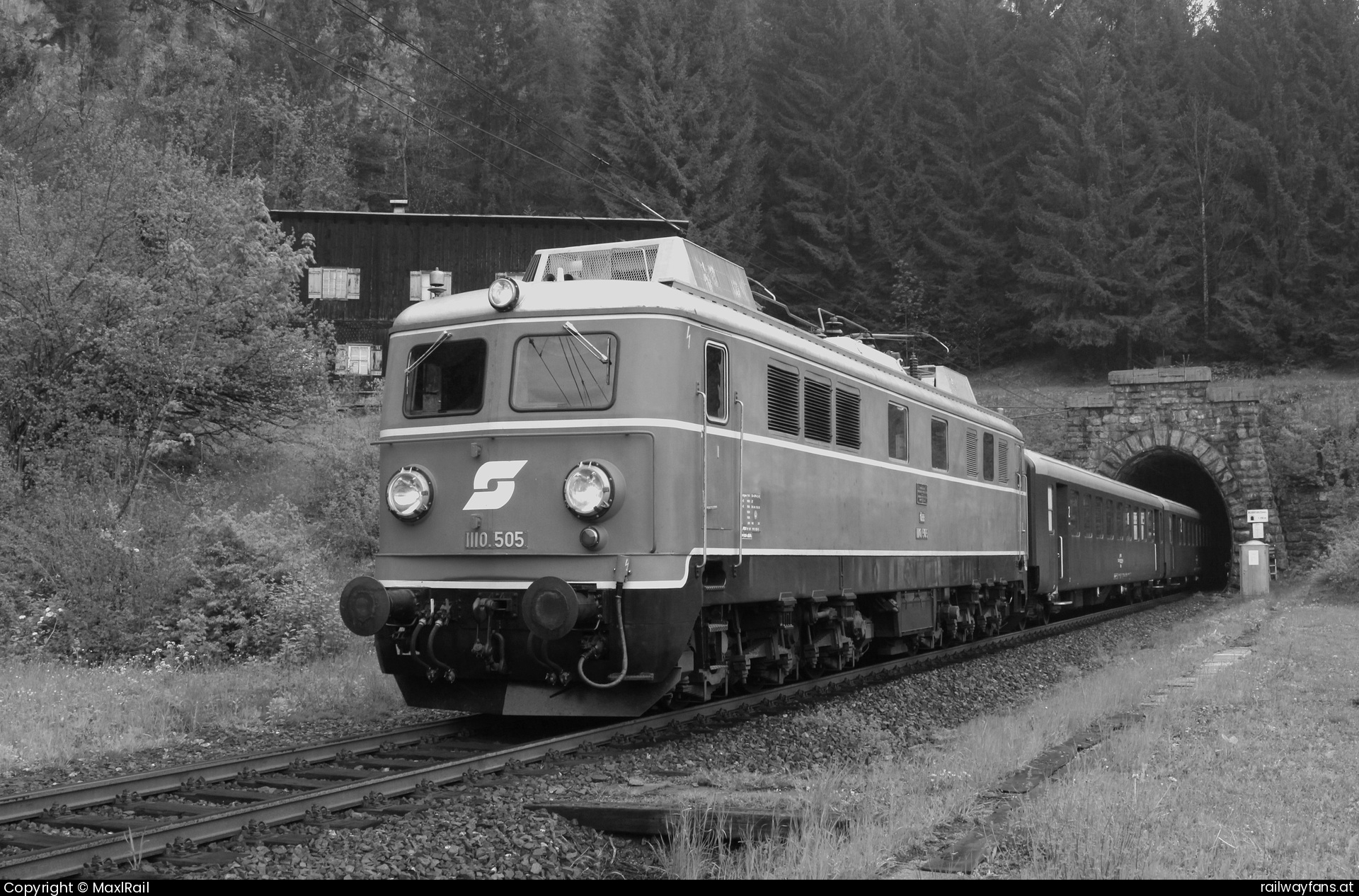 Pro Bahn Vorarlberg 1110 505 in Wald am Arlberg mit dem SLP 14496 - Kurz vor dem Bahnhof Wald am Arlberg rollt die 1110.505 mit einem Personenzug von Landeck kommend talwärts in Richtung Bludenz und hat den 1158m langen Wildentobeltunnel verlassen.
Die 1110.505 fuhr mit drei vorbildlich restaurierten 
