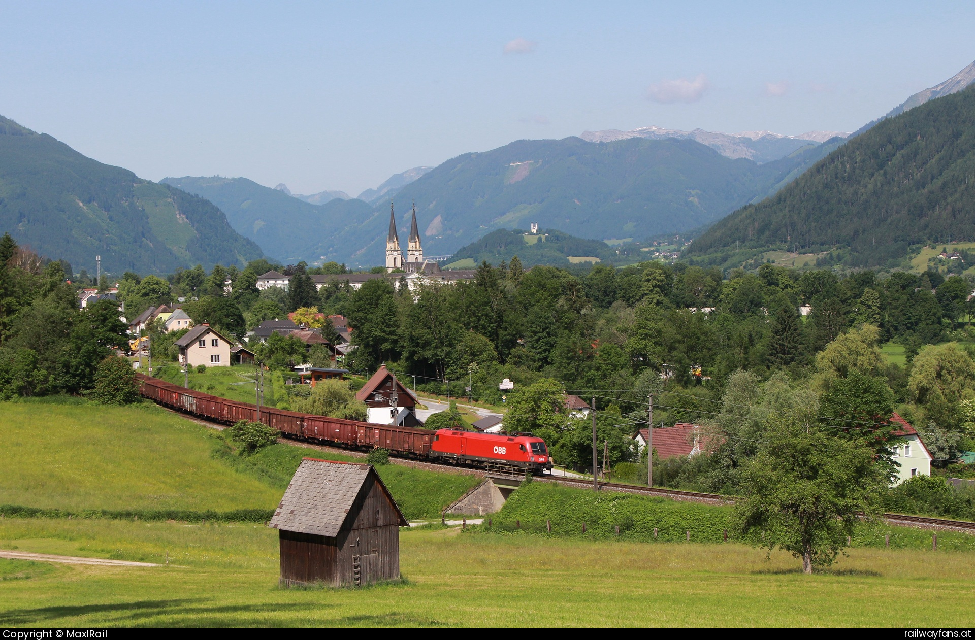 ÖBB 1116 188 in Admont - Links und rechts der Enns erheben sich hohe Berge, es liegen Dörfer und Ortschaften an ihr und die Eisenbahn führt meist in Sichtweite den Fluss entlang.
In Admont führt die Kronprinz Rudolf Bahn etwas abseits durch den Ort.
Die 1116 188 verlässt hier am 6.6.2025 den Bahnhof mit einem Kohlezug von Jesenice nach Linz Stahlwerke.  Gesäusebahn Railwayfans