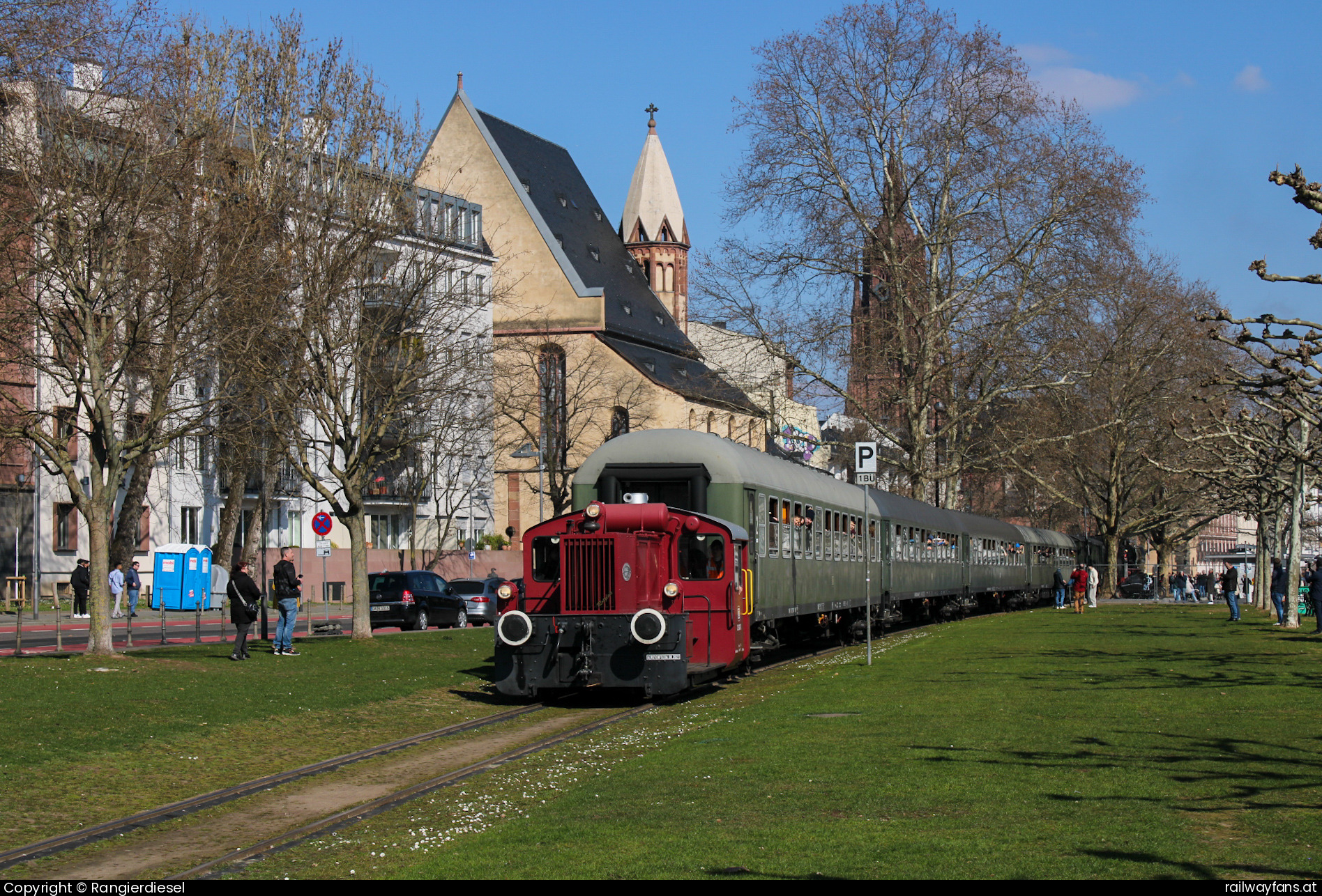 Historische Eisenbahn Frankfurt  322 607 in Mainkai - Am 15.03.2025 zerrte die 1934 von Krauss-Maffei gebaute 322 607-3 ihren Sonderzug mit 52 4867 am Zugschluss auf der Frankfurter Hafenbahn aus dem Haltepunkt Eiserner Steg heraus in Richtung Griesheim. Im Hintergrund ist die Kirche St Leonhard zu sehen.   Railwayfans