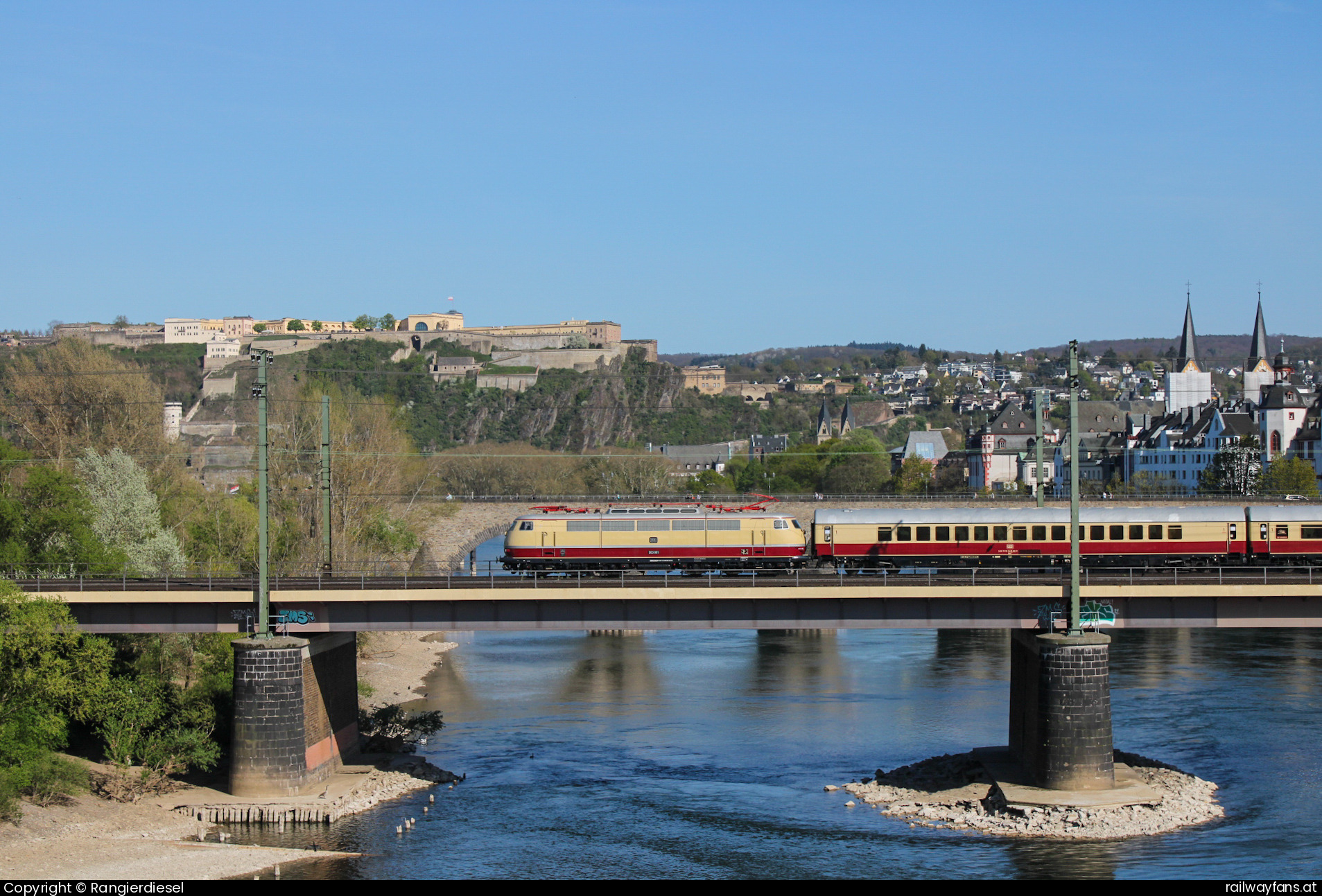 DB Museum 103 001 in Koblenz-Stadtmitte  - Am 12.04.2025 veranstaltete AKE Eisenbahntouristik mit ihrer Rheingold Garnitur und der E03 001 des DB Museums ging es von Köln aus einmal nach Koblenz und wieder zurück. Dabei wurde fast ausschließlich rechtsrheinisch gefahren und nur zwischen der Hochheimer Brücke und der Urmitzer Rheinbrücke wurde linksrheinisch gefahren. Nach dem ein Winner KLV mich fast zum Loser gemacht hätte, indem er fast die ganze Brücke und damit die Sicht auf die E03 blockierte, gelang es doch noch, ein Bild der Fuhre mit der Festung Ehrenbreitstein im Hintergrund anzufertigen.

  2630 Railwayfans